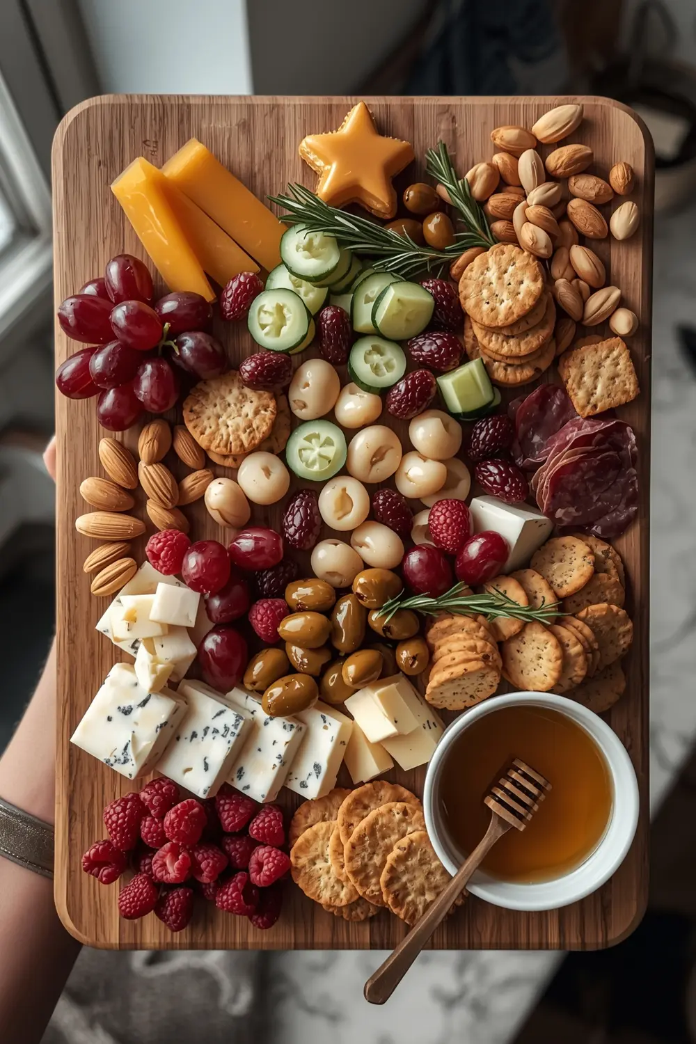 A charcuterie board arranged to resemble a Christmas tree, with various cheeses, meats, fruits, and nuts