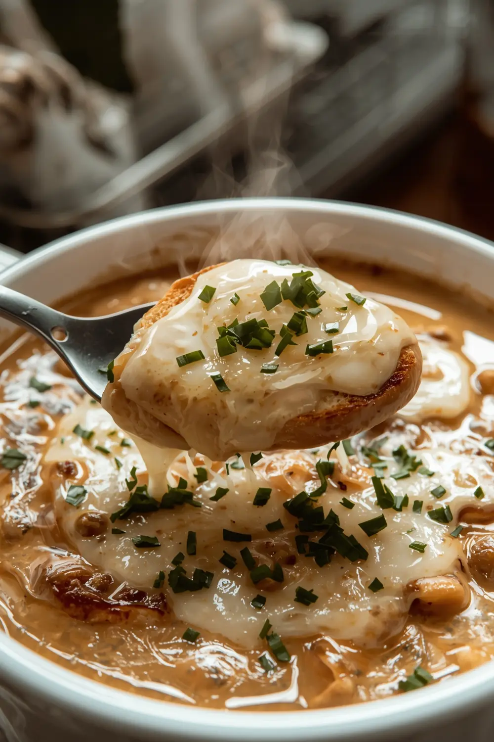 A photo of French Onion Soup in a bowl, topped with toasted baguette, melted cheese, and parsley