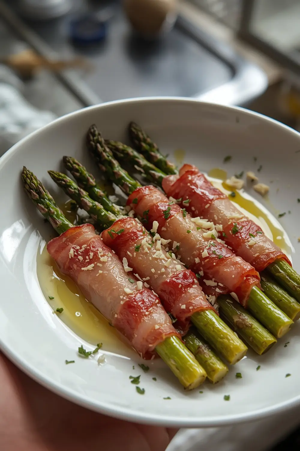 Asparagus wrapped in bacon on a white plate